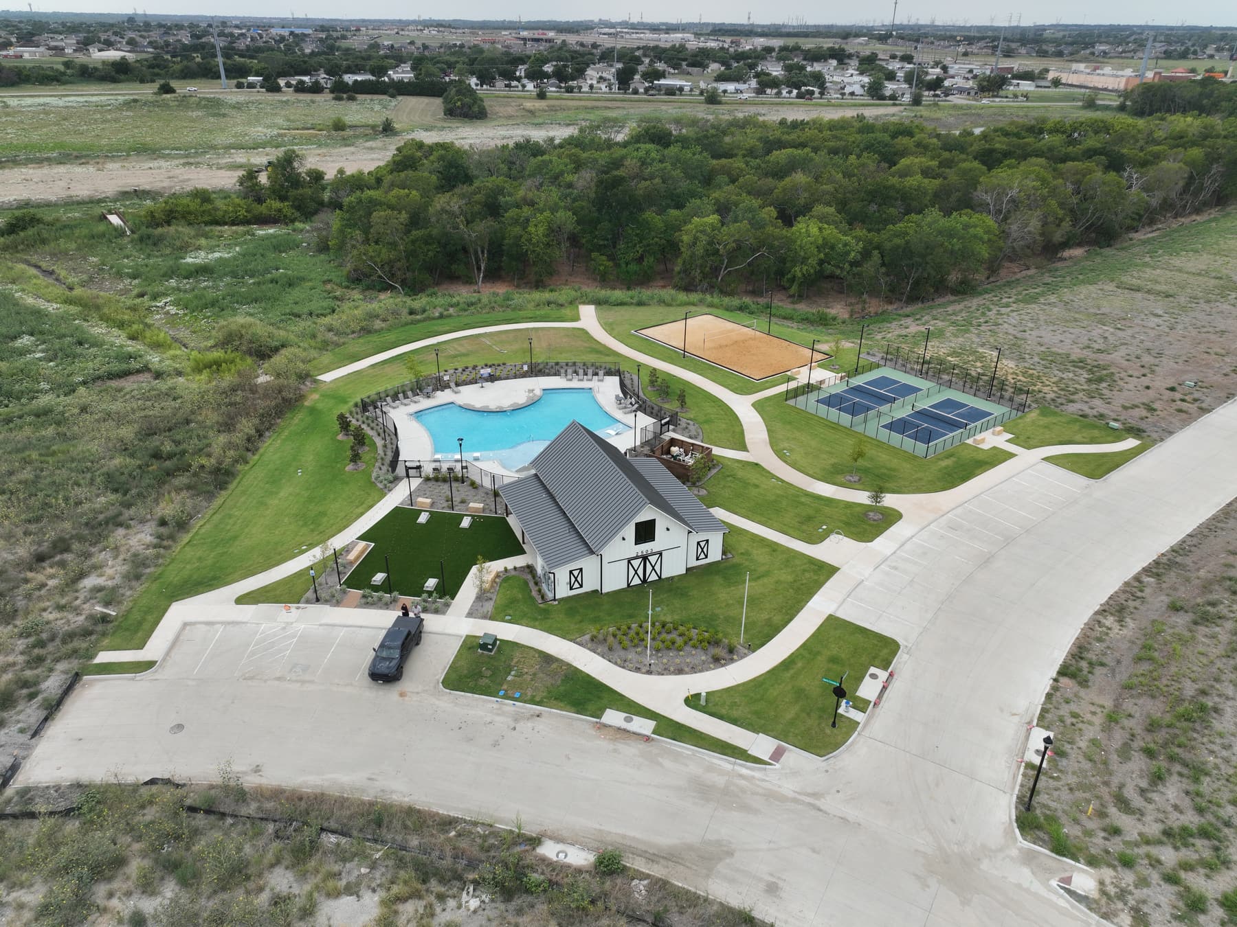 Aerial view of the completed amenity center at Liberty Crossing in Royse City, Texas, with pool, pickleball courts, and sand volleyball