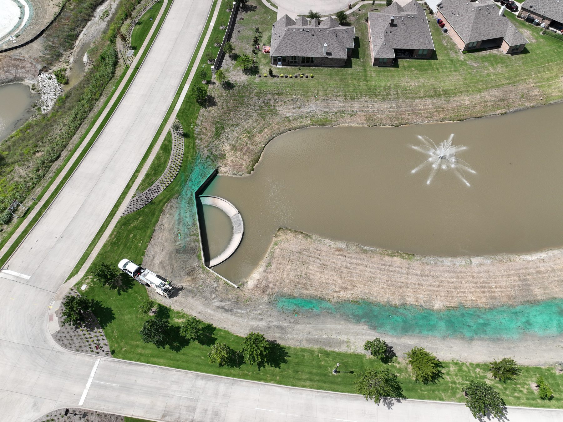 Aerial view of an aerated pond and landscaped open space backing onto finished homes at Clearview Ranch in Royse City, Texas