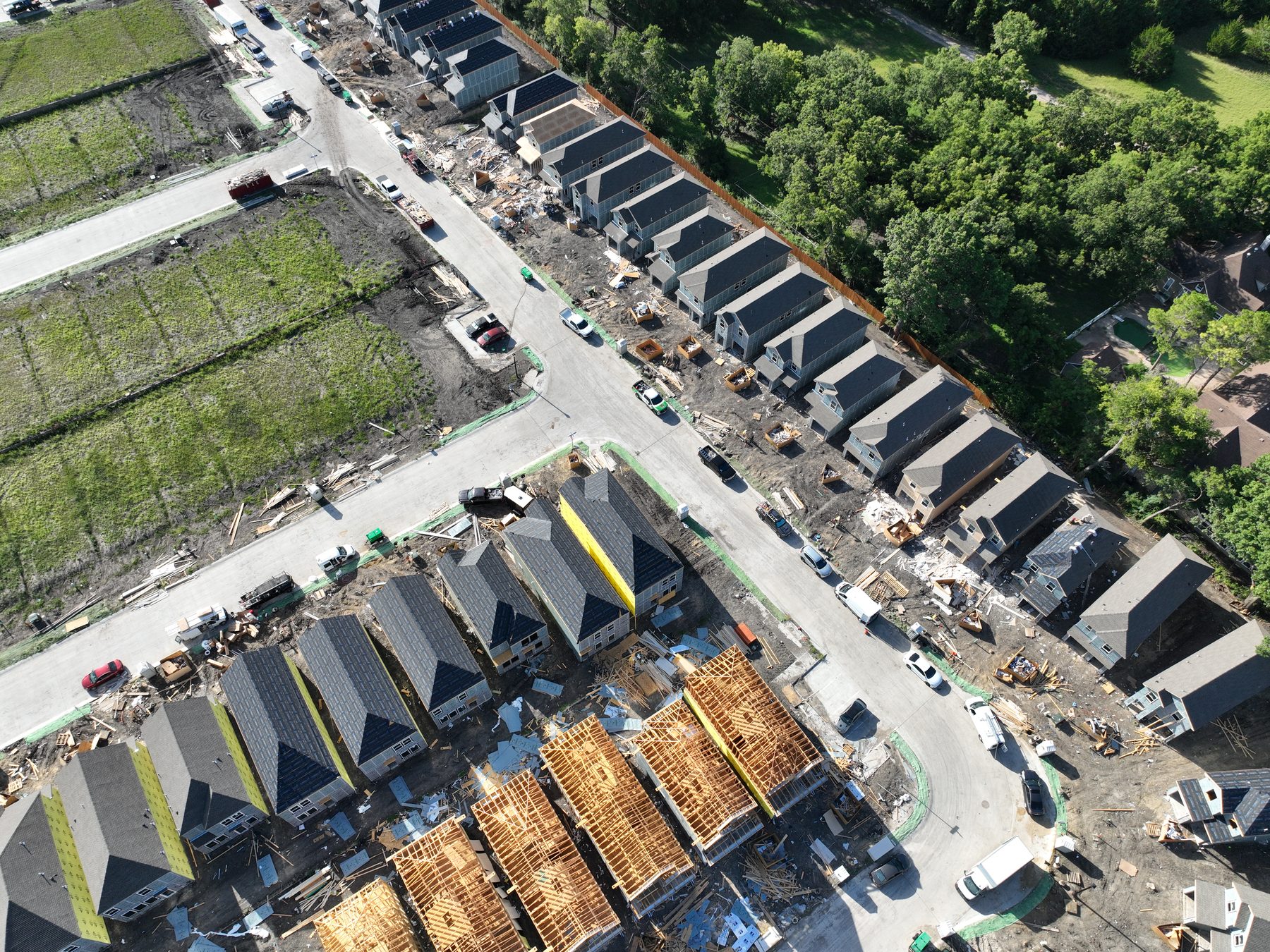 Aerial view of completed and framing homes lining a finished street at Arbor South in Princeton, Texas
