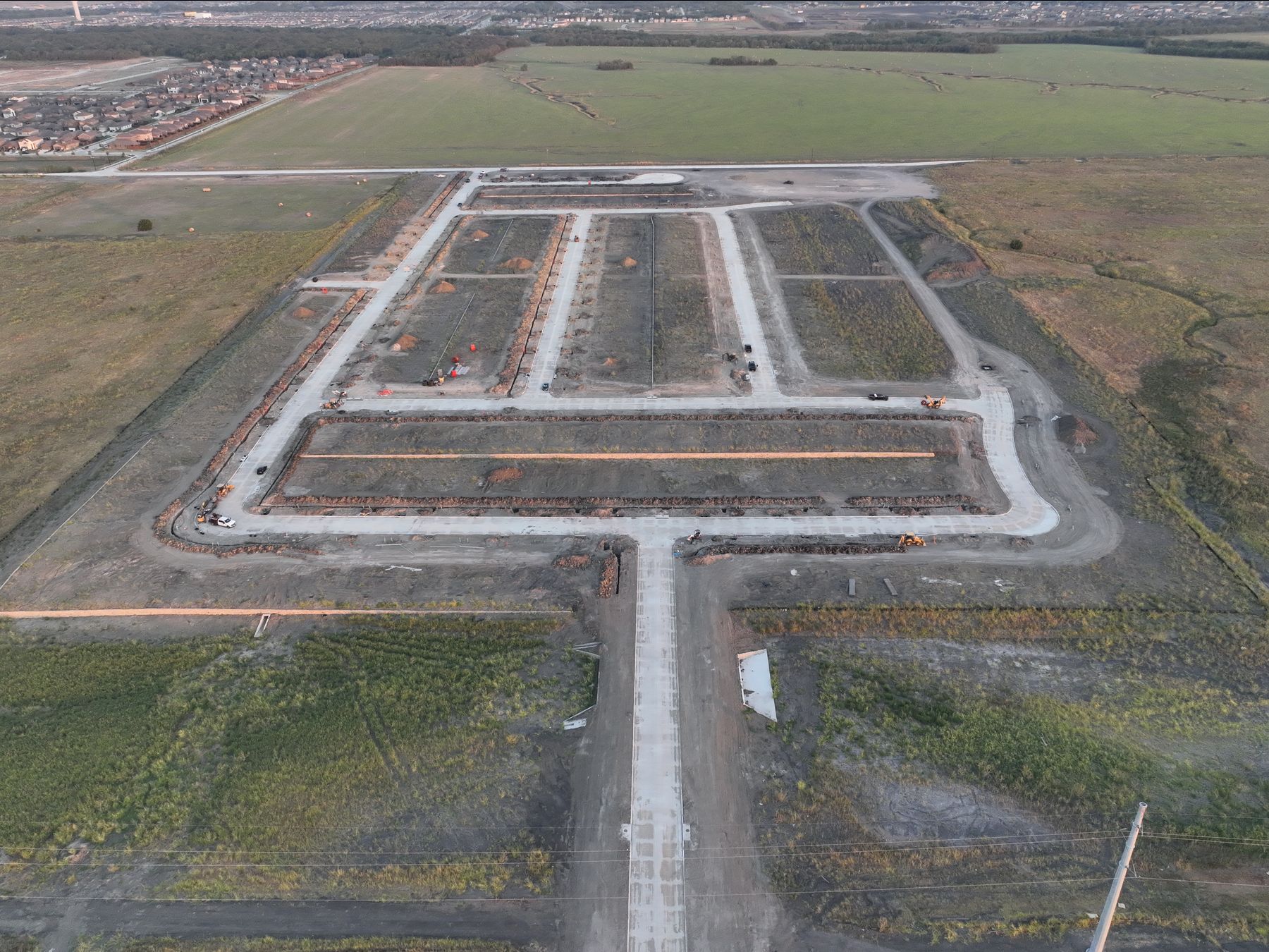 Aerial view of newly paved streets and graded homesites under development at Cartwright Mays in Crandall, Texas