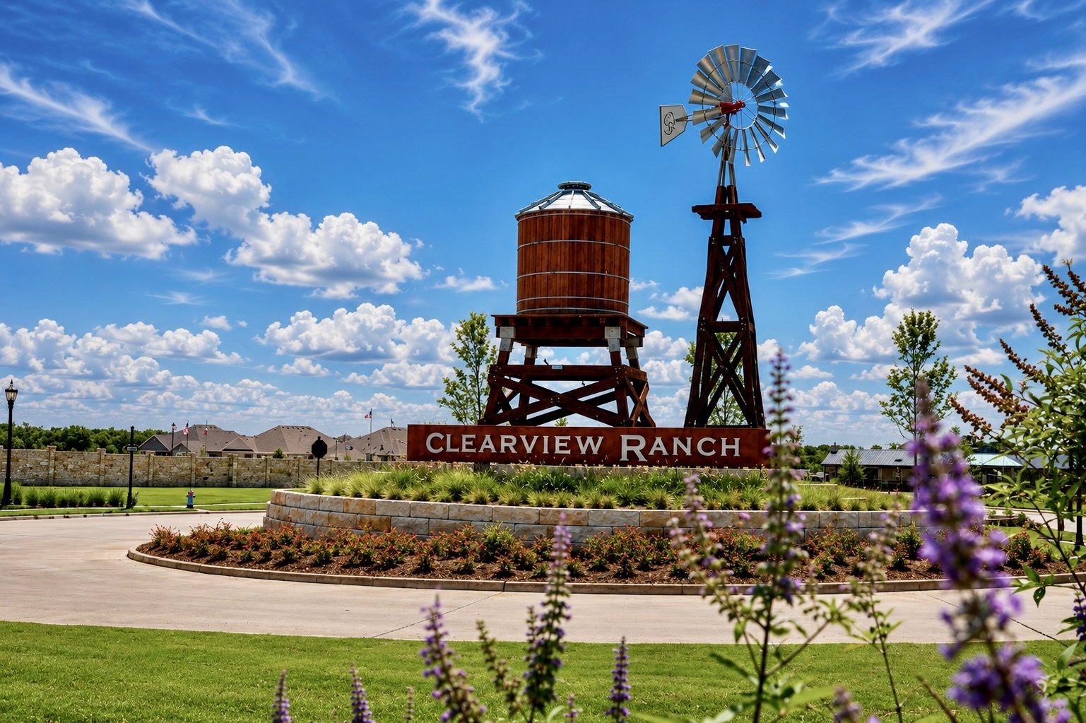 The Clearview Ranch entry monument in Royse City, Texas — a timber water tower and windmill above the community sign, with landscaped beds and homes beyond