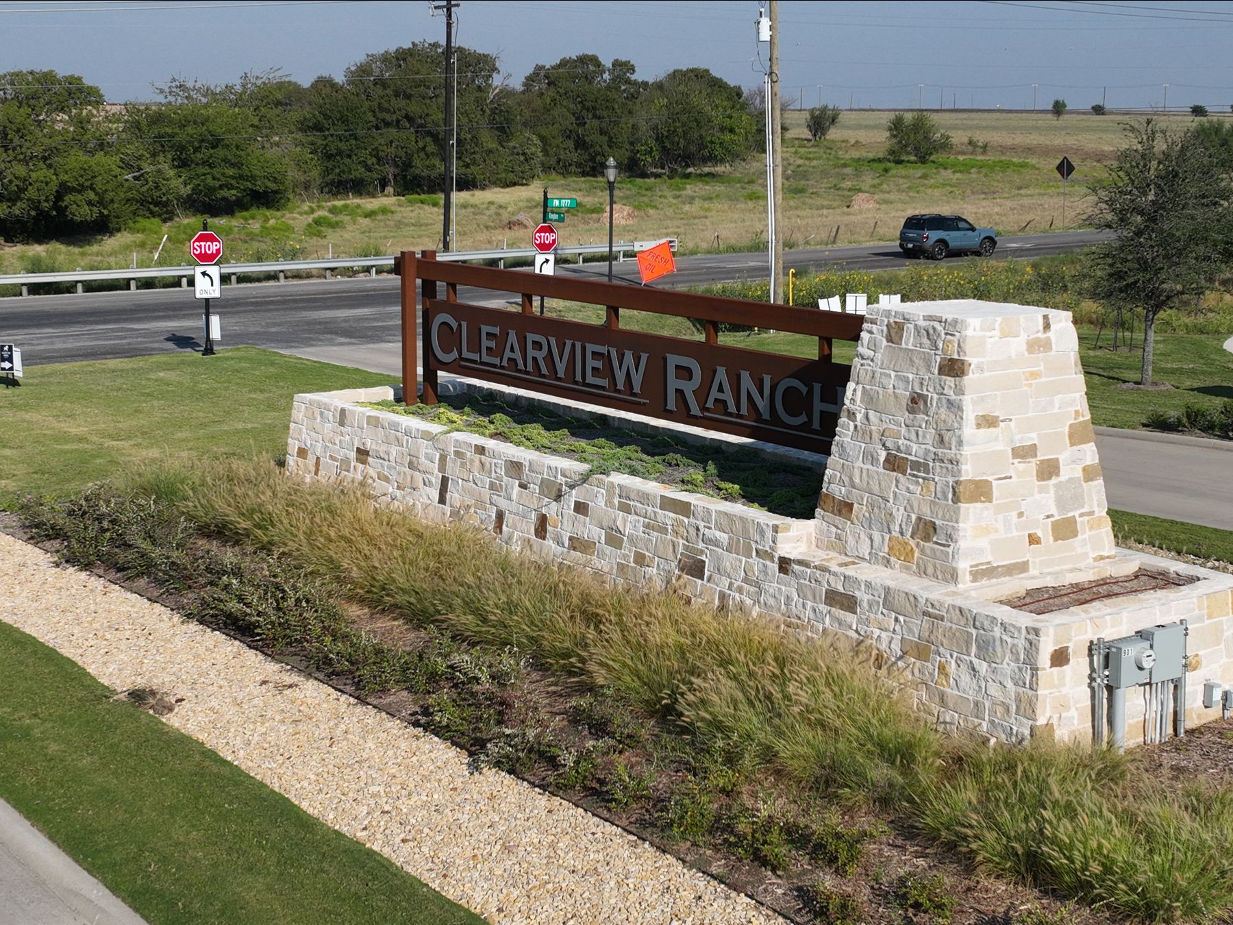 The Clearview Ranch stone and timber entry sign at the highway in Royse City, Texas, set in native grasses beside the road