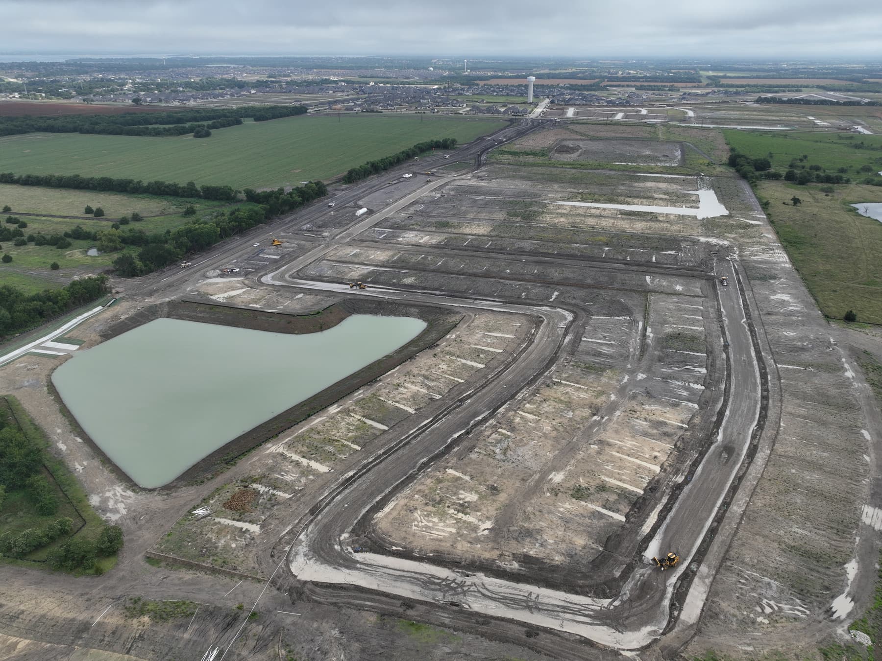 Aerial view of graded homesites and a detention pond under development at Elevon Section 5, Phase 2 in Lavon, Texas
