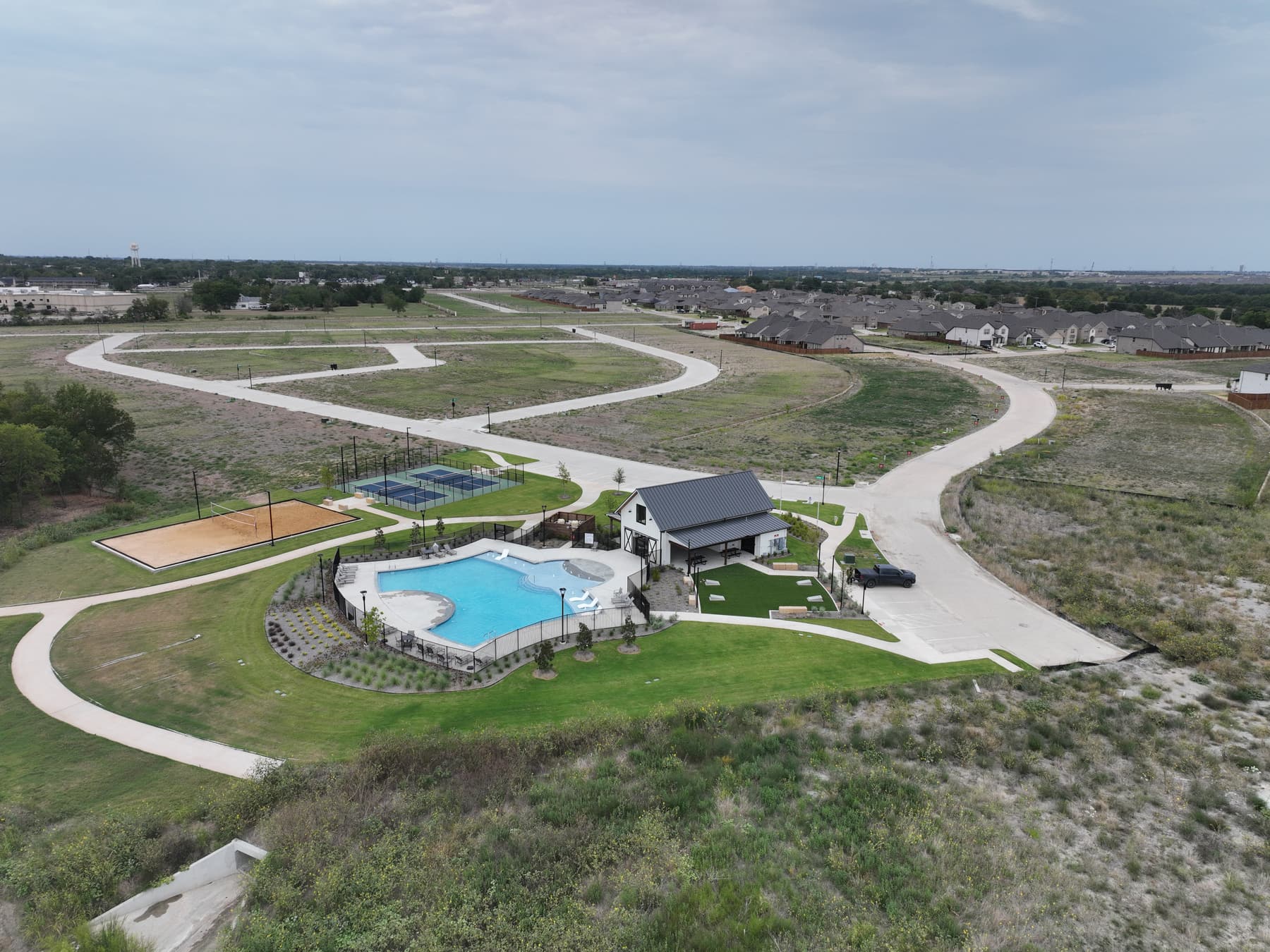 Aerial view of the amenity center at Liberty Crossing in Royse City, Texas, with pool, pickleball courts, and sand volleyball