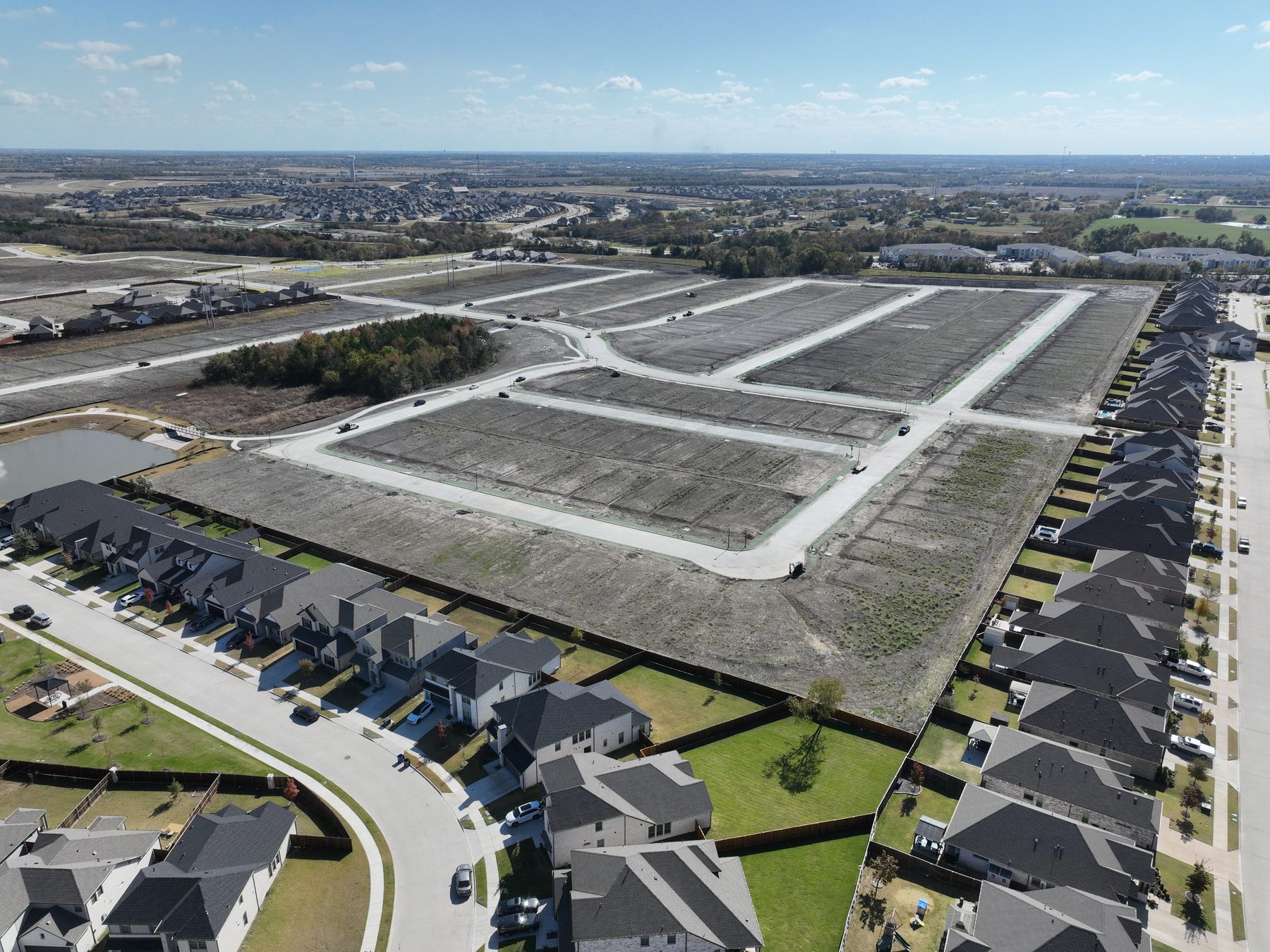 Aerial view of finished streets, curbs, and graded homesites handed over to the builder at Elevon Phase 4 in Lavon, Texas