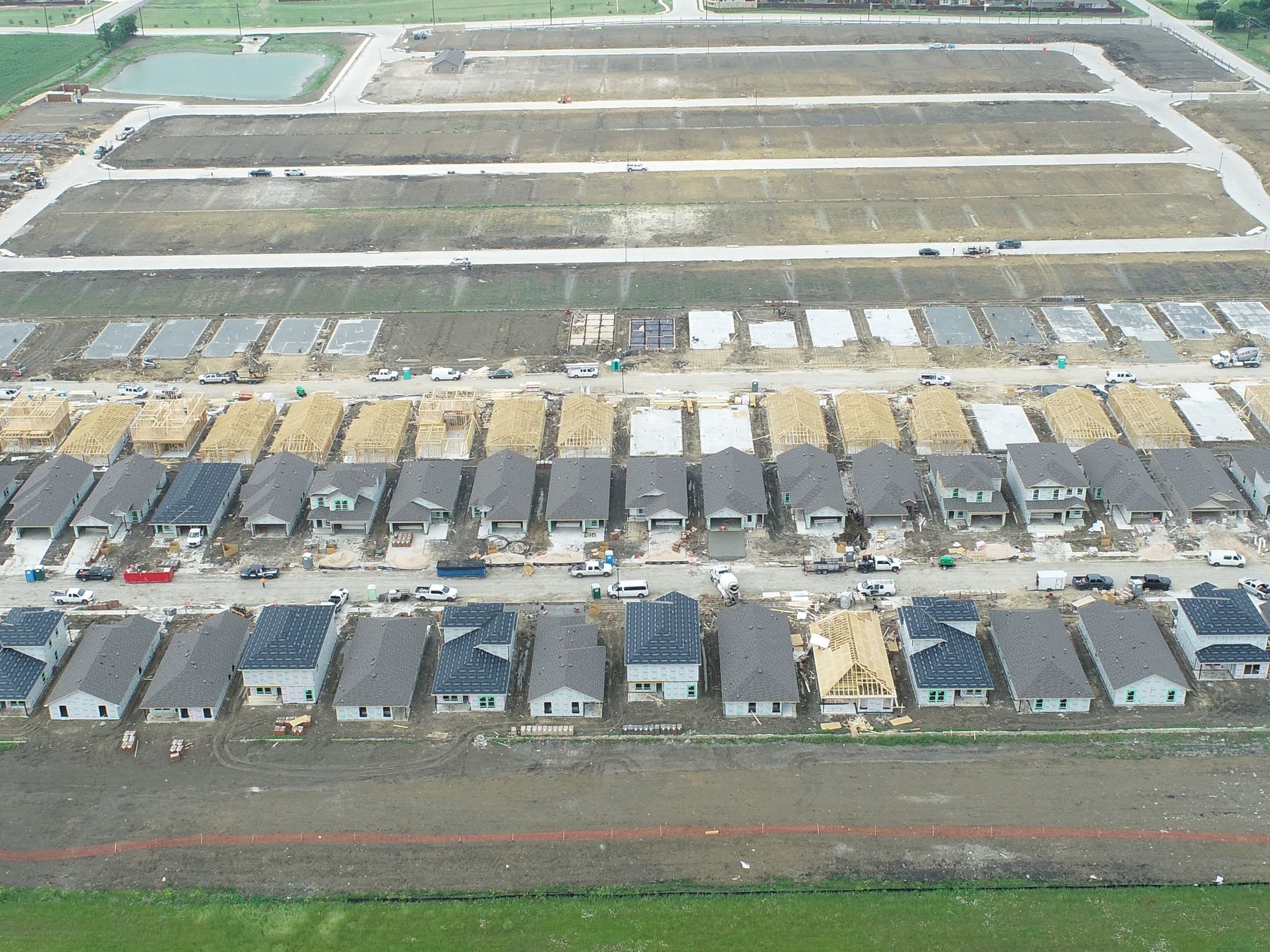 Aerial view of rows of finished and framing homes on delivered lots at Magnolia Phase 10 in Josephine, Texas