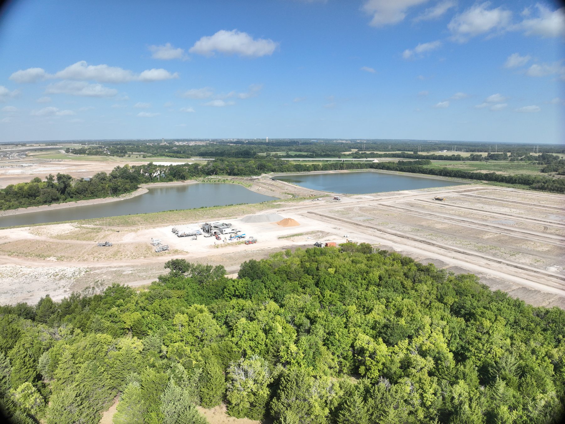 Aerial view of a completed detention pond and graded homesites at Riverstone Estates Phase 1 in Melissa, Texas