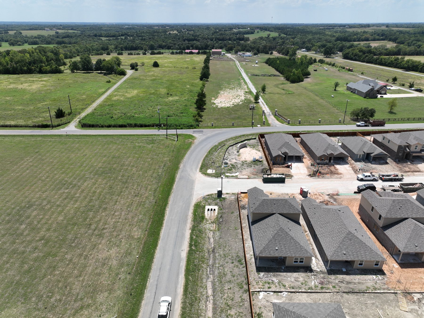 Aerial view of a completed streetscape of occupied homes with mature lawns at Sweetwater Springs in Sherman, Texas